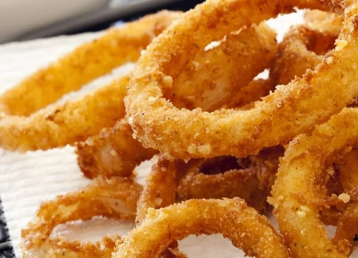 Crispy air fryer onion rings served on a plate with dipping sauce
