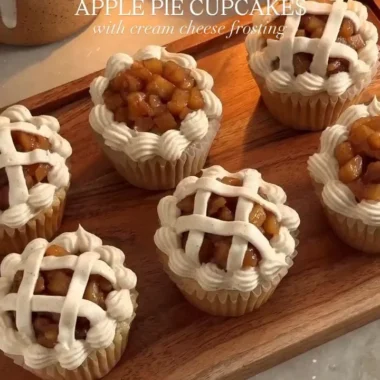 Apple pie cupcakes topped with frosting and apple slices.