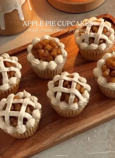 Apple pie cupcakes topped with frosting and apple slices.