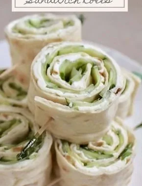 Cucumber and cream cheese sandwich rolls served on a plate