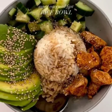 A colorful healthy rice bowl filled with vegetables, protein, and grains.