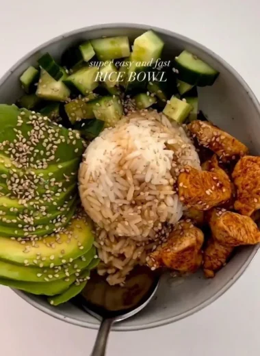 A colorful healthy rice bowl filled with vegetables, protein, and grains.
