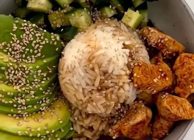 A colorful healthy rice bowl filled with vegetables, protein, and grains.