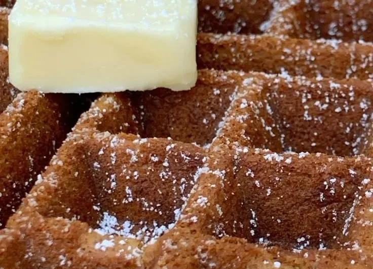 Delicious homemade gingerbread waffles topped with syrup and spices.