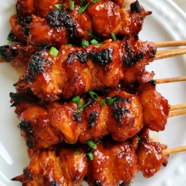Grilled Korean chicken skewers with vibrant vegetables on a platter
