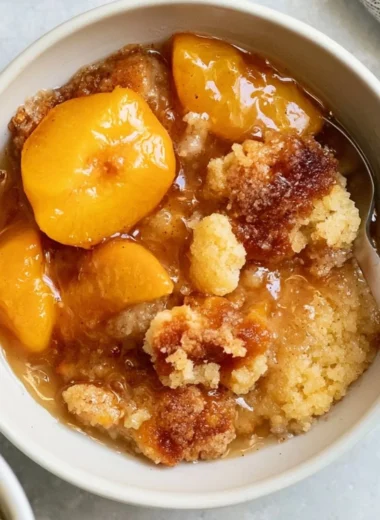 Delicious homemade Southern peach cobbler served in a rustic dish.