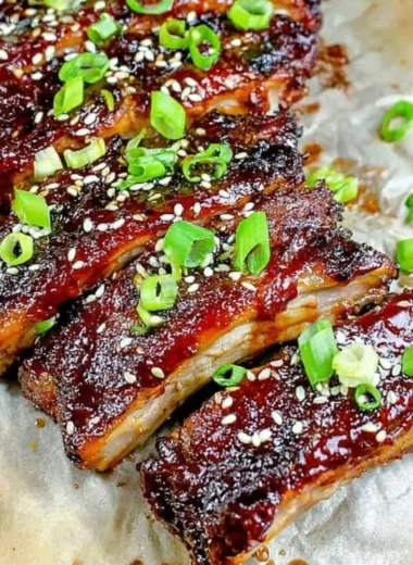 Delicious sticky Asian ribs served on a plate, showcasing rich glaze and garnishes.