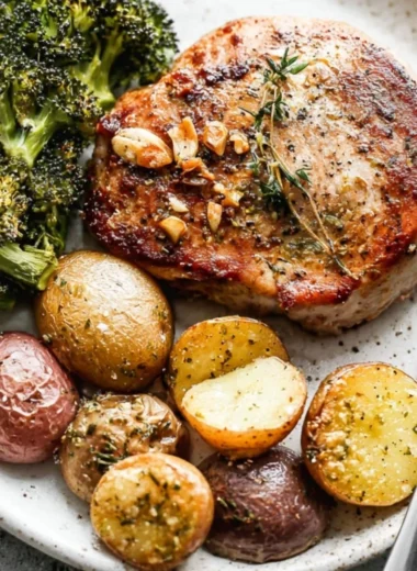 Sheet pan pork chops with roasted potatoes and broccoli, a cozy dinner recipe.