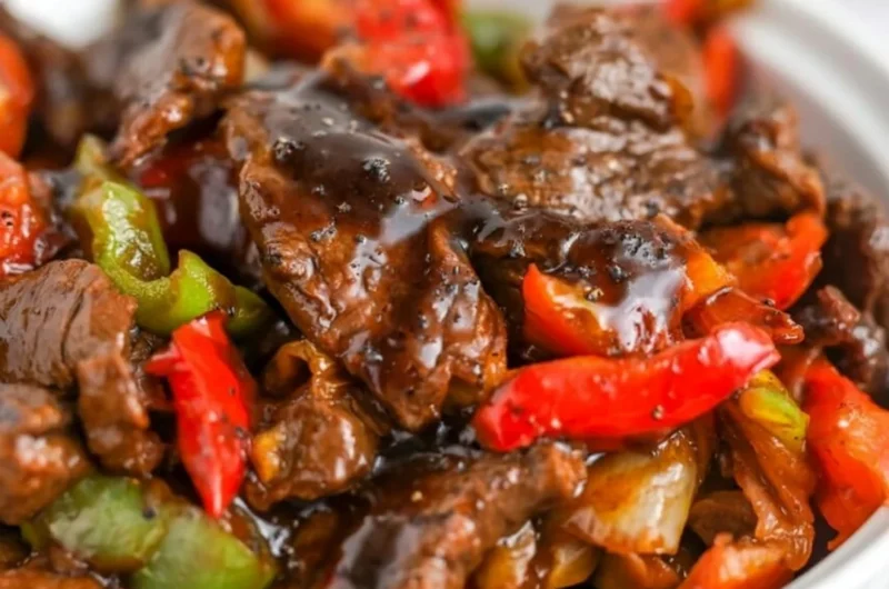 Plate of delicious black pepper beef served with vegetables and rice