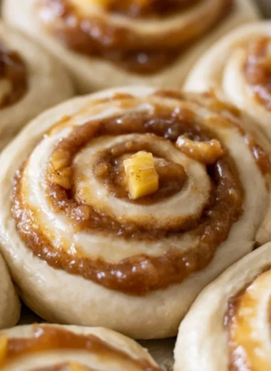 Freshly baked caramel apple cinnamon rolls drizzled with caramel sauce