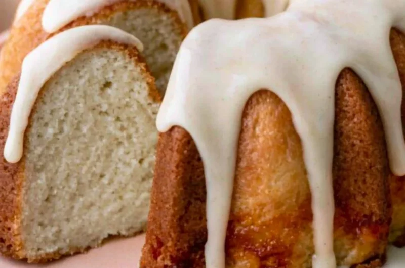 Moist vanilla bundt cake drizzled with icing on a decorative plate