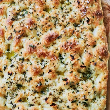Homemade focaccia bread topped with herbs and olive oil