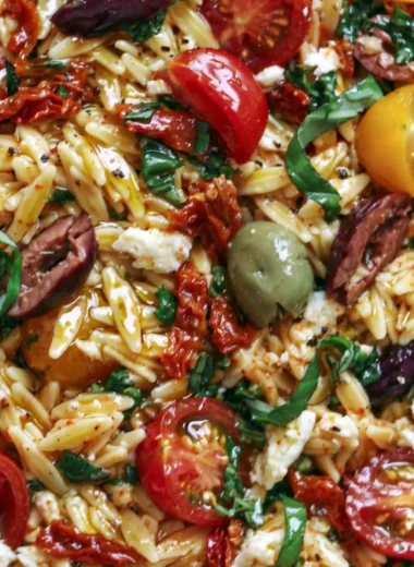 Delicious Greek Orzo salad with tomatoes, olives, basil, and feta cheese.