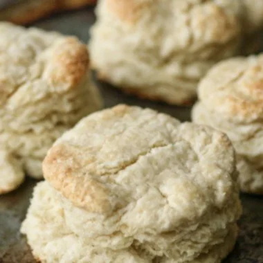 Freshly baked homemade buttery biscuits on a kitchen table