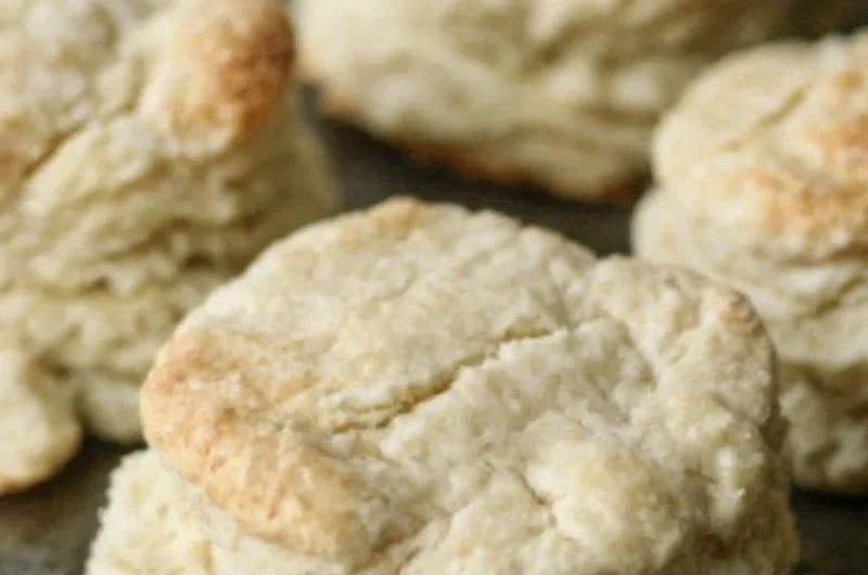 Freshly baked homemade buttery biscuits on a kitchen table