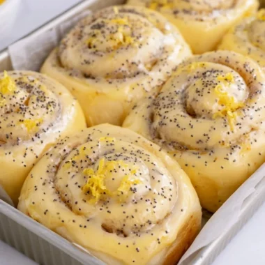 Freshly baked lemon rolls on a plate garnished with lemon slices