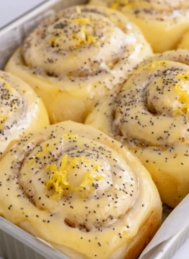 Freshly baked lemon rolls on a plate garnished with lemon slices