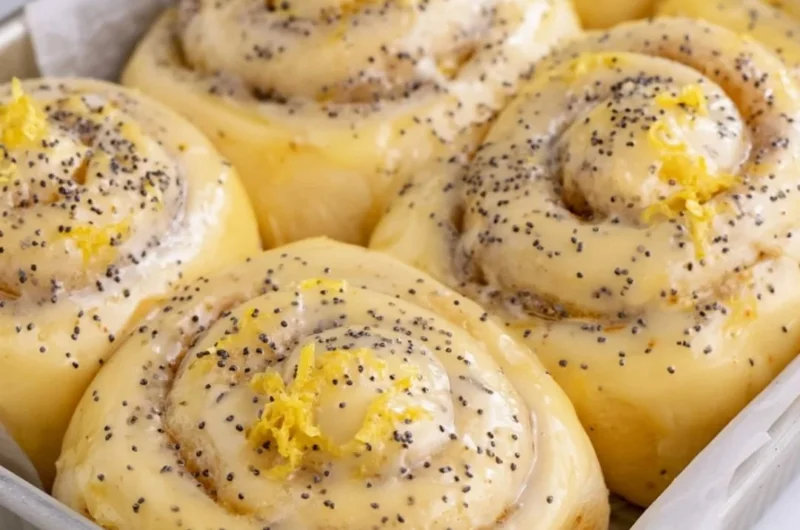 Freshly baked lemon rolls on a plate garnished with lemon slices