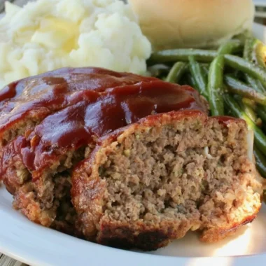Delicious Old Fashioned Meatloaf served on a wooden plate