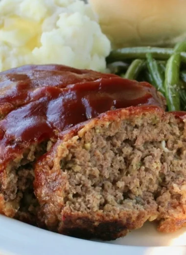 Delicious Old Fashioned Meatloaf served on a wooden plate