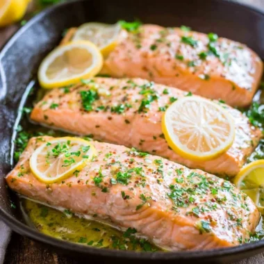 Delicious oven roasted salmon garnished with herbs and lemon slices
