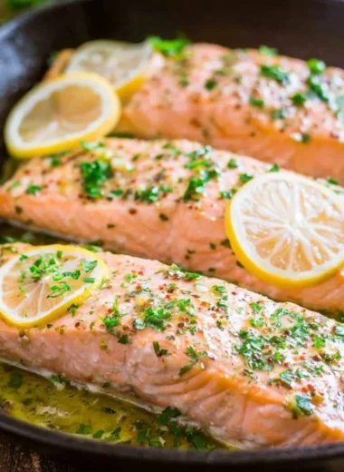 Delicious oven roasted salmon garnished with herbs and lemon slices