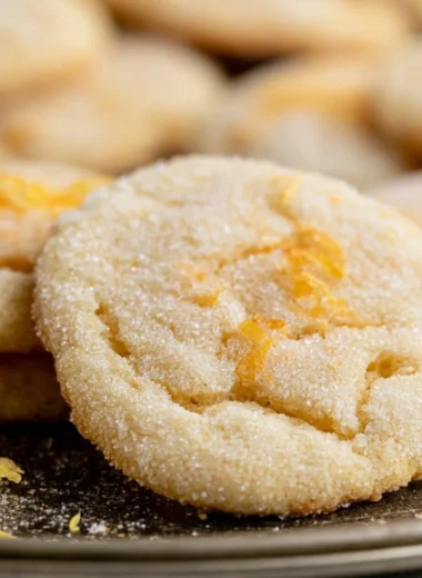 Soft and chewy lemon cookies on a baking sheet, freshly baked and golden.