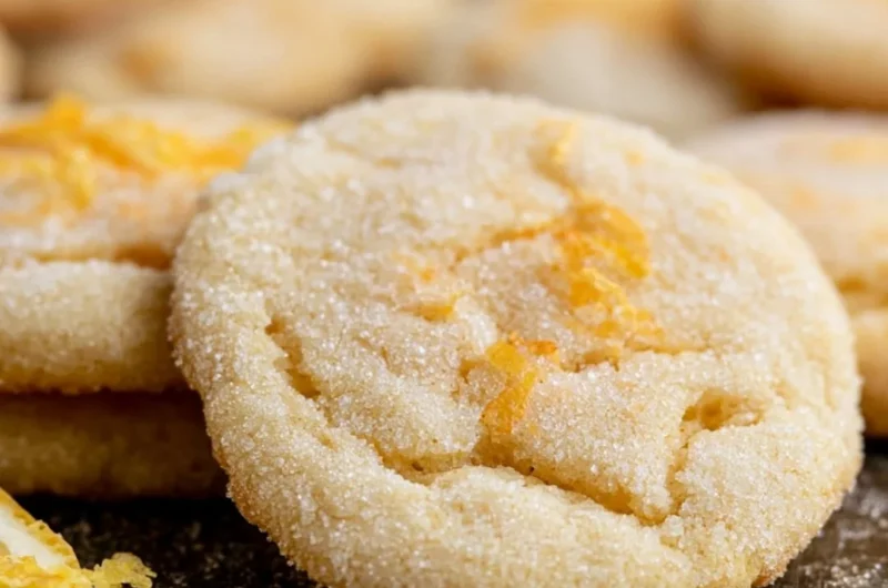 Soft and chewy lemon cookies on a baking sheet, freshly baked and golden.