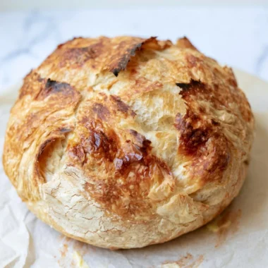 Freshly baked sourdough croissant bread with a golden crust and flaky layers.