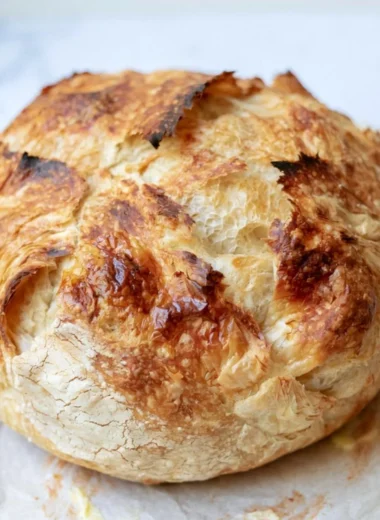 Freshly baked sourdough croissant bread with a golden crust and flaky layers.