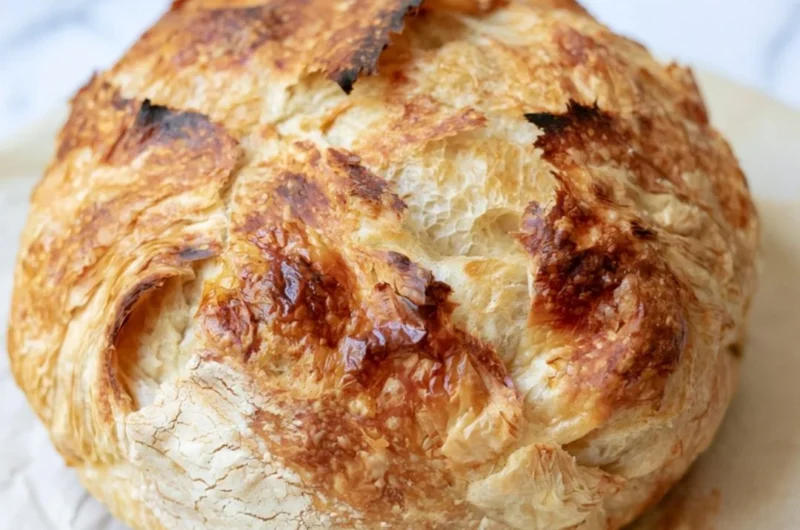 Freshly baked sourdough croissant bread with a golden crust and flaky layers.