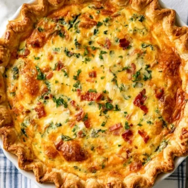 Cheesy spinach quiche with turkey bacon served on a plate