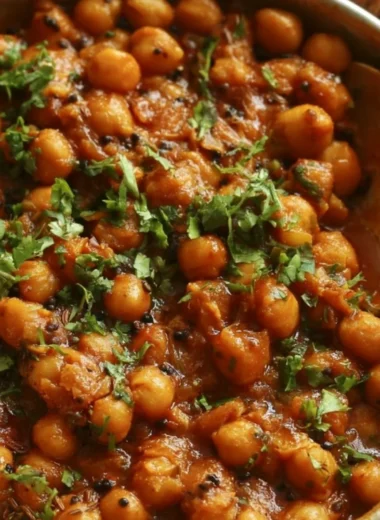 Bowl of cozy Chickpea Masala garnished with fresh herbs and spices.